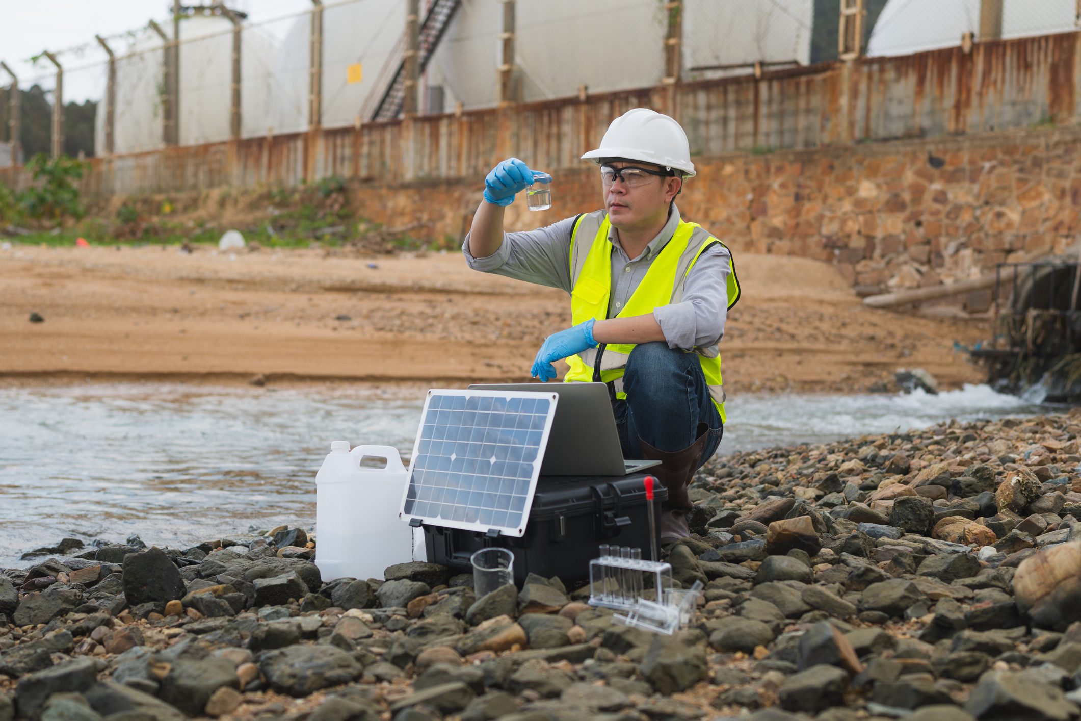 Technician examining water sample outdoors